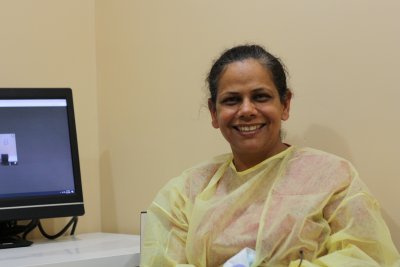 Dr Pardeep Dhillon sits in office next to a computer