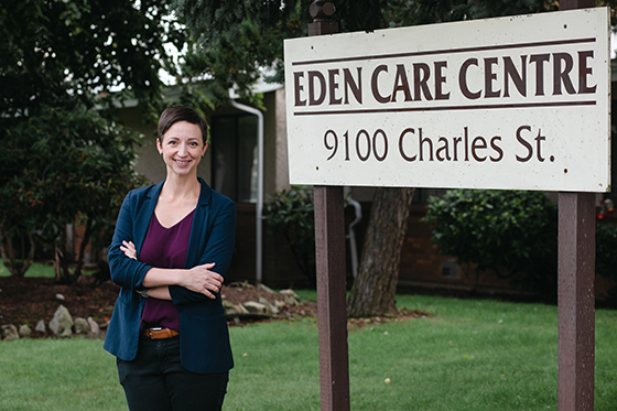 Dr Dara Donnelly stands in front of sign for Eden Care Centre