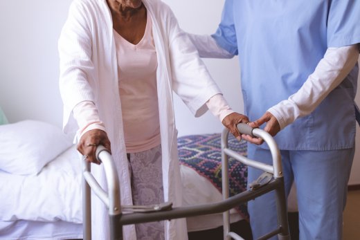 elderly woman with walker and her doctor